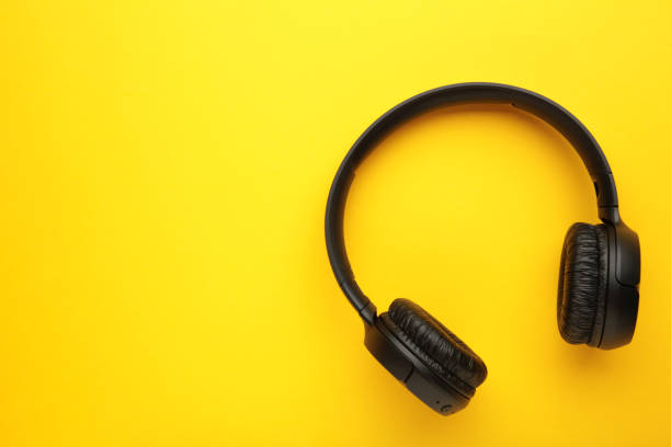 istock Black, modern wireless headphones on a yellow background. 1457698109