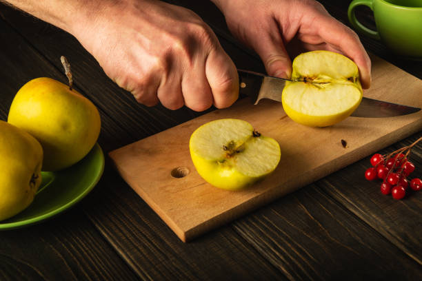 istock Making apple jam at home. Hands of a chef with a knife cutting fresh apples on a cutting board 1457700672