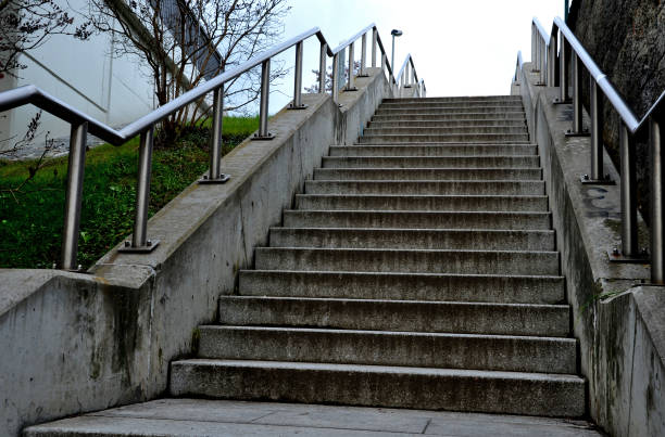 istock staircase with concrete sides at a public building. the safe staircase has two handrails, one with a reduced height for children under 12 at the entrance to the school, drone view, top, point of 1457701043