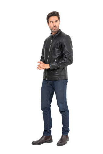 Handsome middle-aged hispanic stubby bearded man on white studio. Short-haired handsome man in leather jacket, t-shirt and jeans, on white background.
