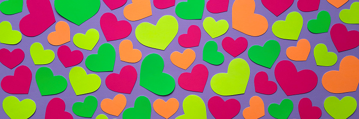 Multicolored heart shapes cut out of paper. Template for website header, cover. Concept of bright emotions, fun, holiday.