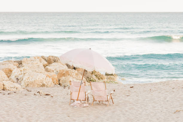 Boho Striped Pink & White Beach Umbrella & Folding Beach Chairs on Palm Beach, Florida at Sunset