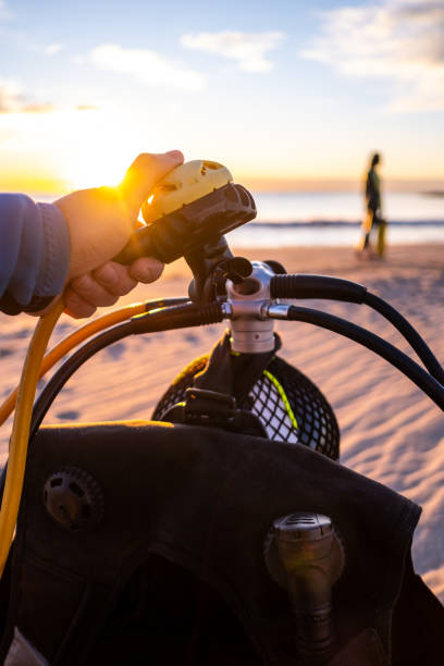 hände einer person, die tauchausrüstung am strand im morgengrauen vorbereitet. standpunkt. - oxygen tank underwater diving diving wetsuit stock-fotos und bilder