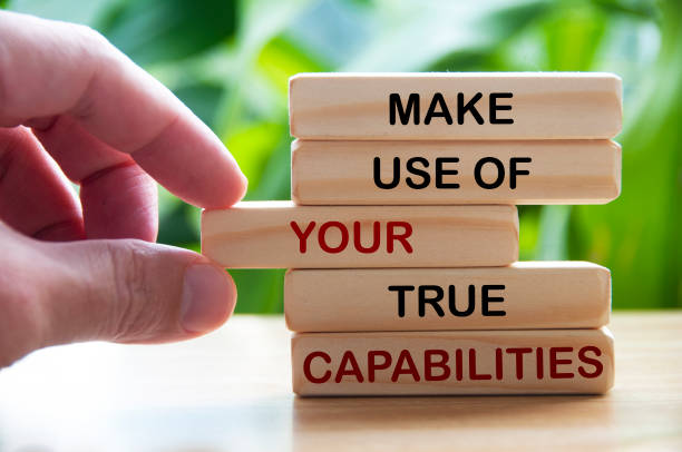istock Make use of your true capabilities text on wooden blocks with hand and blurred nature background. Motivational concept 1457705399