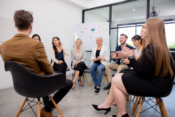 istock Group of team business people sitting a circle brainstorming and training while leader explaining and presentation at office, seminar and meeting with diversity, business and community concept. 1457706396