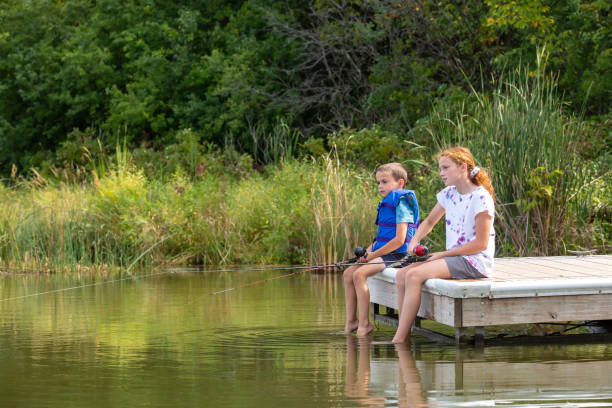 istock Brother & Sister Fishing From Dock 1457712775