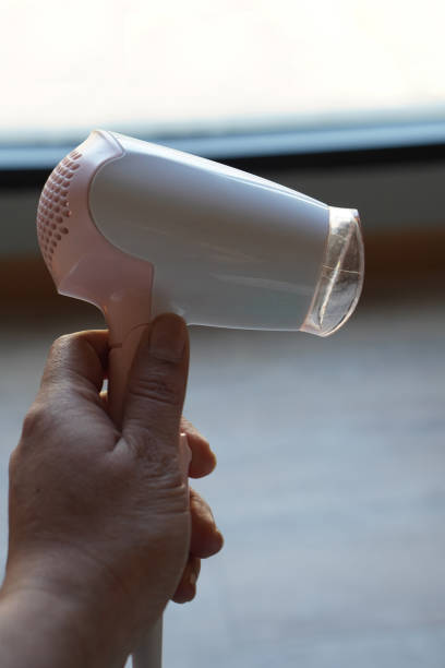 istock front view hand holder pink and white plastic hair dryer, blur background, object, technology, electronic, copy space 1457713439
