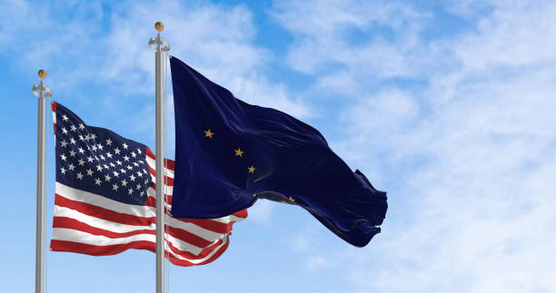 istock Alaska and US flags waving on sunny day 1457715169