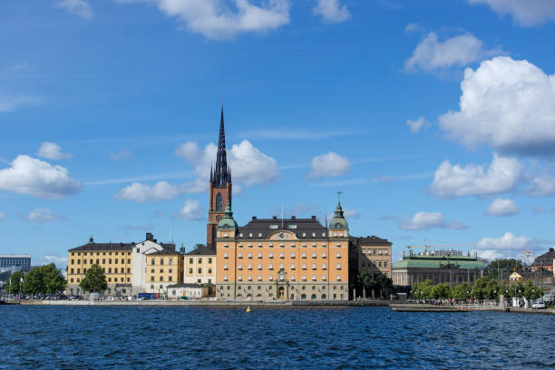 istock View of buildings by river against cloudy sky 1457715171