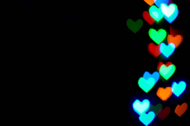 istock Multi colored blurred lights in the shape of hearts in the dark. 1457715360