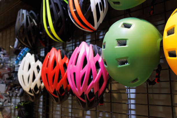 capacetes de segurança para bicicletas pendurados na parede de metal em uma loja de bicicletas. - capacete de ciclismo - fotografias e filmes do acervo