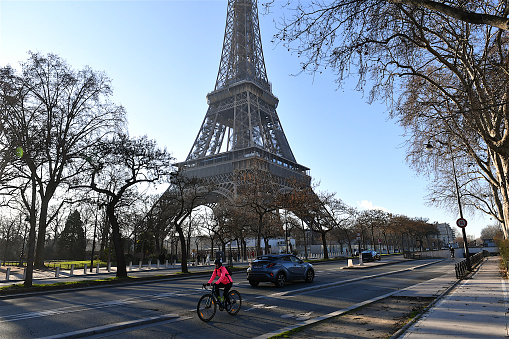 Paris, France-01 18 2023: Cyclist on a bicycle path in Paris, passes the Eiffel tower, France.