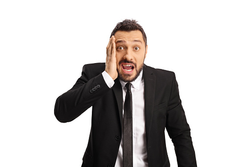 Shocked businessman holding his cheek isolated on white background