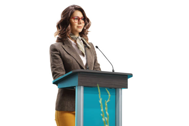 istock Young woman speaker on a pedestal giving a speech 1457720351