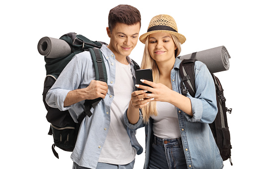 Young male and female backpackers looking at a smartphone isolated on white background