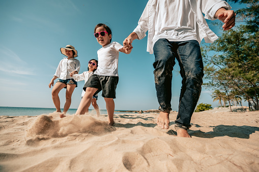 Asian family vacation at the beach with family relationships.Happy family travel on beach in holiday,Summer and vacations concept.