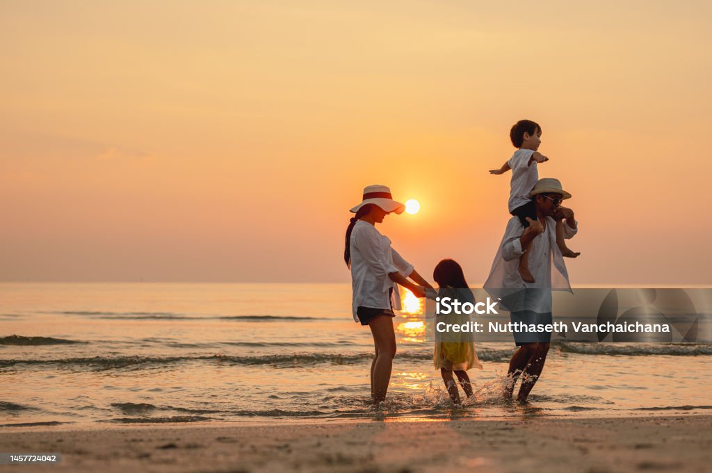 여름 방학 동안 해변 활동을 즐기는 행복한 아시아 가족. 부모와 자녀는 해변에서 일몰 바다를 즐깁니다. 휴일 여행 개념, 여름 휴가. - 로열티 프리 가족 스톡 사진 여름 방학 동안 해변 활동을 즐기는 행복한 아시아 가족. 부모와 자녀는 해변에서 일몰 바다를 즐깁니다. 휴일 여행 개념, 여름 휴가. - 로열티 프리 가족 스톡 사진