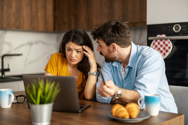 istock Unhappy, stressed and upset couple paying bills with a laptop 1457725010