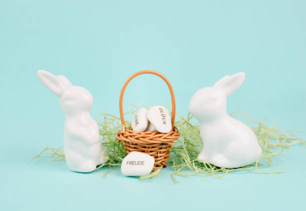istock Wicker basket and easter bunny, words like love, luck and joy are standing in german language on the pebbles, rabbit brings gift and wishes 1457726424
