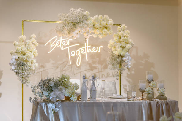 istock Festive table with arch decorated composition flowers and greenery, candles in hall restaurant. Table newlyweds covered with a tablecloth in banquet area on wedding party. Table setting, reception. 1457726531