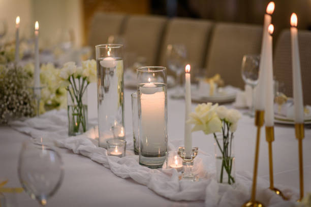 istock Table setting, serving closeup. Wedding setup detail. Banquet decoration in hall restaurant. Luxury reception. Festive table covered tablecloth, decorated composition flowers and candles in party area 1457726550
