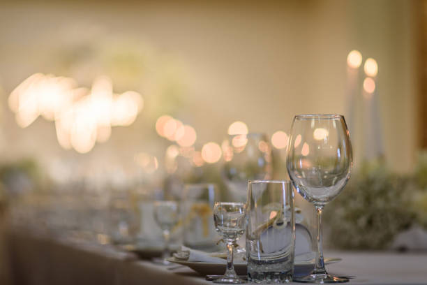 impostazione della tavola, primo piano di servizio. dettaglio allestimento matrimonio. decorazione del banchetto nel ristorante della hall. accoglienza di lusso. tovaglia coperta da tavolo festivo, fiori e candele decorati composizione nell'area della fest - wedding venue foto e immagini stock