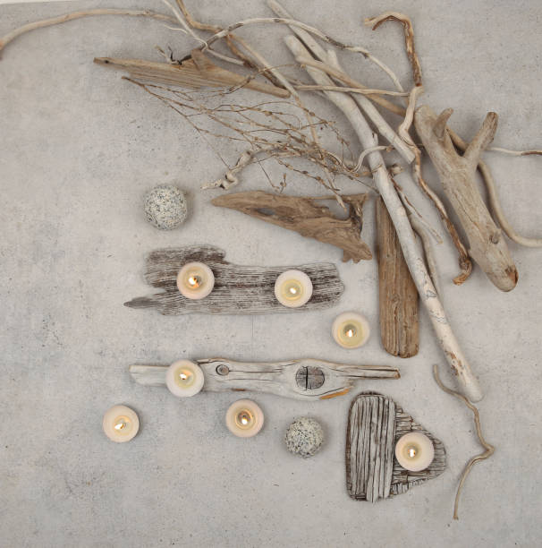 istock Sea driftwood pieces and tea light candles on stone background. 1457728926