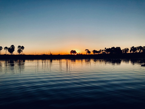 Beautiful sunset in the Okavango Delta with the calming ripple of water