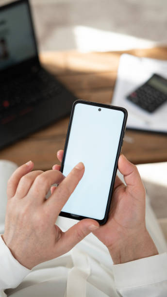 istock Close-up Woman using phone with blank screen at home 1457732264