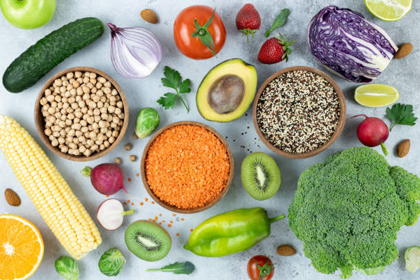 健康的な食事のきれいな食べ物の選択:灰色の背景に果物、果実、野菜、豆類、ナッツ。平面図。食べ物の背景。