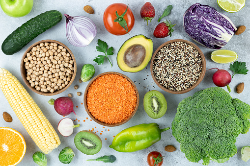 Healthy eating clean food selection: fruits, berries, vegetables, legumes, nuts on a gray background. Top view. Food background.