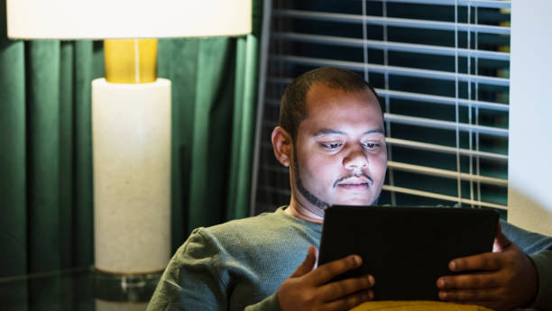 istock Young multiracial man watching tv on digital tablet 1457736969