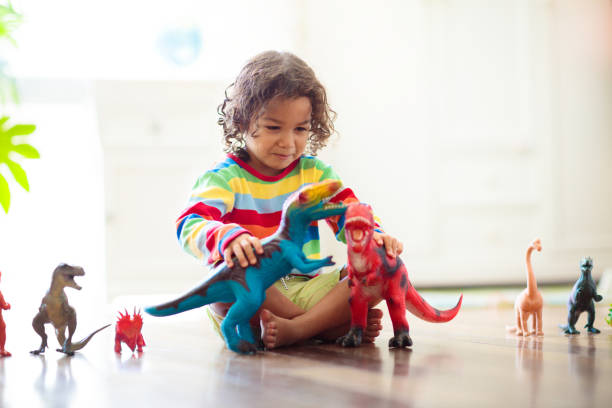 istock Child playing with toy dinosaurs. Kids toys. 1457737672
