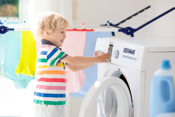 istock Child in laundry room with washing machine 1457738130