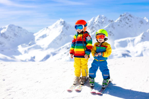 divertimento invernale con sci e neve per i bambini. bambini che sciano. - snow gear foto e immagini stock