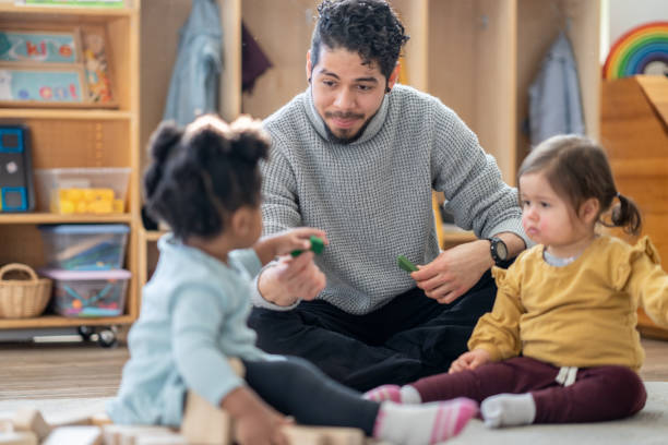istock Male Daycare Educator with Children 1457739736