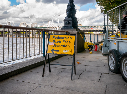 A sign reading “Pedestrian Step free Diversion” - pointing towards the River Thames from the South Bank, London, whilst repair works are being undertaken to the paving on the embankment.