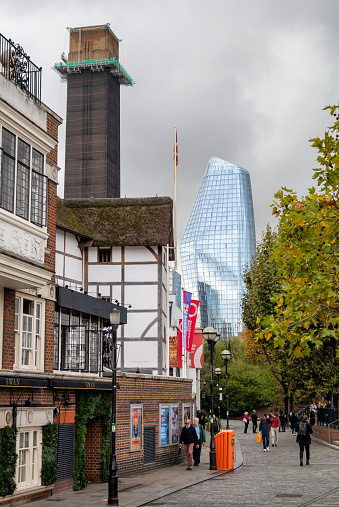 Buildings along Bankside, in the London borough of Southwark, on the southern bank of the River Thames, is home to many interesting and historic buildings. Here, the half-timbered building is the reconstructed Shakespeare’s Globe, with the chimney of Tate Modern art gallery behind it and One Blackfriars tower gleaming against a grey sky. Bankside is always busy with tourists.