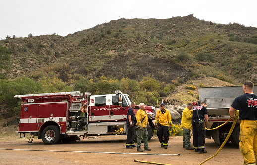 Fire fighters roll up hoses and prepare to leave the site of a electrical fire in Littleton, Colorado’s Waterton Canyon. The only casualty of a fire, were the charred remains of a rat lying near the road. According to fire fighters at the scene, they got the call at 3:30am of a fire near the Strontia Springs Dam along the South Platte River in Waterton Canyon on September 21, 2022. West Metro and the U.S. Forest Service fire fighters quickly put out the flames which were climbing the steep canyon walls. According to fire fighters, the source of the fire was located at an electrical box, likely ignited by the rat chewing the wires. The body of the rat was relocated near the road by a firefighter, where it remained and later decomposed.