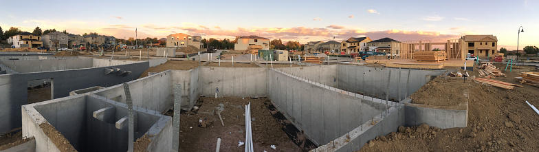 At sunrise in Denver, Colorado on Kipling Ave near West Bellieview, a concrete home foundation stands in the foreground with wooden home skeletons in the background on September 30, 2022.