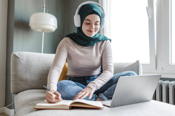 istock A young woman sitting on the couch and working 1457751255