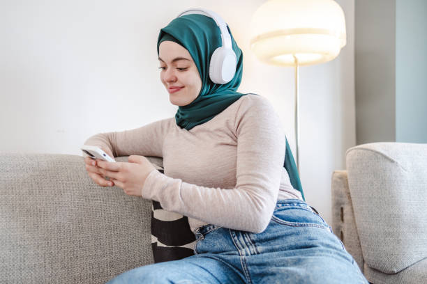 istock Young Muslim woman using smart phone at home 1457751311