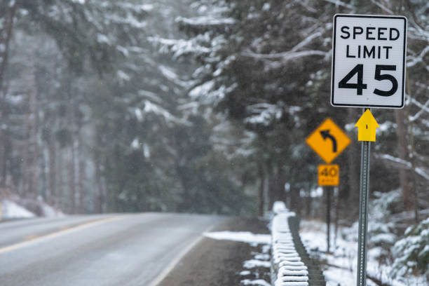 istock Winter road traveling while snowing, in woodland road, wether seasons, copy space 1457751899