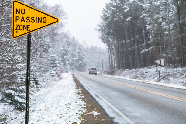 istock Winter road traveling while snowing, in woodland road, wether seasons, copy space 1457751963
