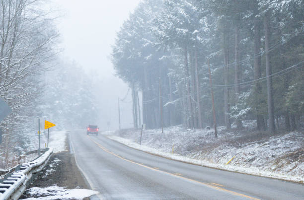 istock Winter road traveling while snowing, in woodland road, wether seasons, copy space 1457752046