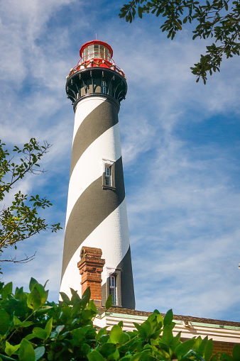 Tourists and visitors stand on the outside balcony of the spiral striped  Saint Augustine Lighthouse (1871) for spectacular views of  the area around the northern end of  Anastasia Island