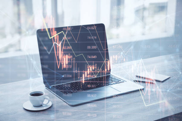 istock Close up of laptop, coffee cup and notepad on desktop with falling red index candlestick graph on screen. Blurry background. Crisis, market fall, recession and money loss concept. Double exposure. 1457753381