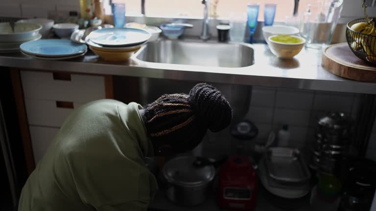 Mid adult woman repairing the kitchen sink at home