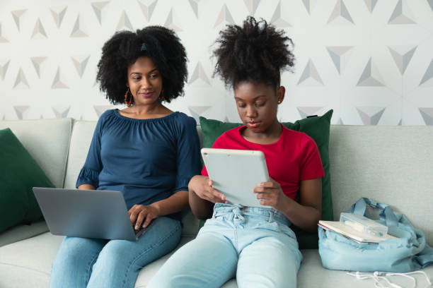 istock daughter uses tablet and mother accompanies her 1457760236