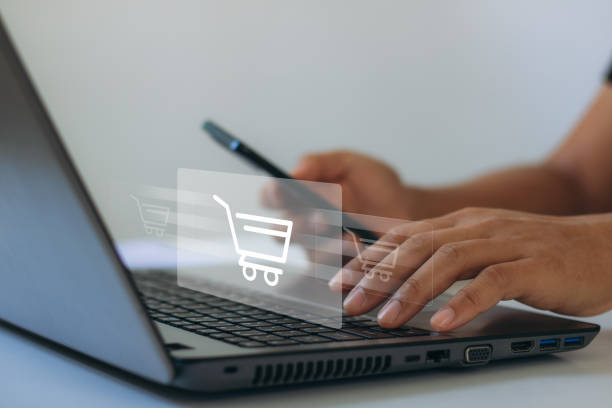 istock eCommerce online shopping concept. Business people using mobile smartphone and laptop computer to order in online store, shopping on internet, concept on virtual screen with hands typing on keyboard 1457762743